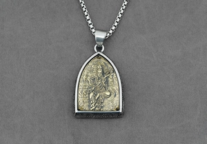 Dettaglio macro del ciondolo Buddha tailandese in acciaio bicolore con catena