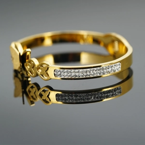 Bracelet papillon en acier doré avec double rangée de cristaux et motifs de cœurs