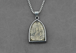 Dettaglio macro del ciondolo ad arco bicolore con rilievo della divinità e catena box