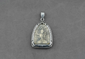 Dettaglio del ciondolo Buddha che mostra il rilievo dorato su uno scudo d'argento