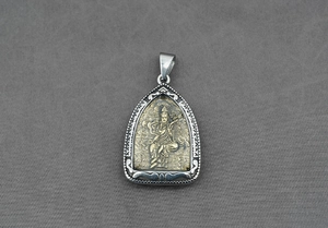 Détail du pendentif religieux avec relief de divinité dorée et cadre en argent