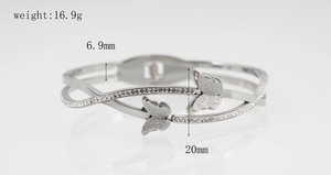 Detail van zilveren vlinderarmring met kristallen inlays en dubbele vlinderdecoratie