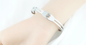 Detail van zilveren roestvrijstalen dubbellaagse armband met veersluiting om de pols