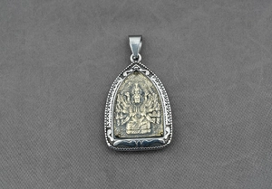 Dettaglio del ciondolo amuleto thailandese con divinità dorata e cornice d'argento