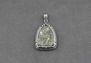 Détail d'un pendentif bouclier bicolore avec relief animal doré et cadre en métal argenté