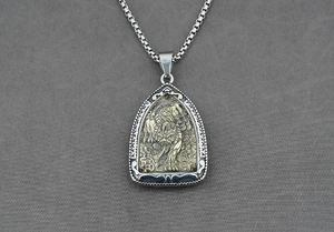 Détail macro du pendentif bouclier vintage pour homme avec tigre en laiton et chaîne box