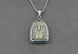 Dettaglio della collana in acciaio al titanio con rilievo di Buddha dorato su scudo