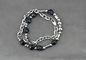 Détail d'un collier punk en acier inoxydable avec des perles de crâne en résine noire