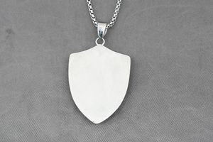 Detail of the brushed metal shield pendant reverse side with a sturdy box chain