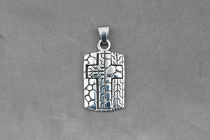 Macro detail of silver vintage cross pendant with embossed geometric textures and bale