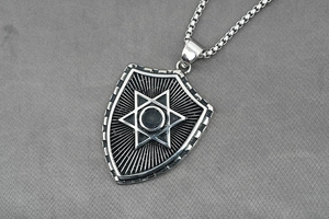 Macro shot of punk shield pendant with hexagram star detail and vintage oxidized steel finish