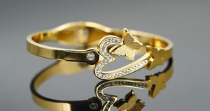 Macro detail of golden butterfly heart bangle with sparkling pave diamonds inlay