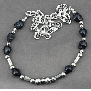 Collier punk gothique avec crânes en argent et perles noires sur fond textile