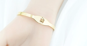 Close-up of golden butterfly bracelet showing the spring hinge buckle for secure wear