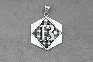 Detailed close-up of a silver hexagonal pendant with an embossed number 13 and mesh texture