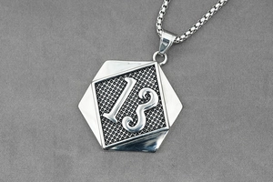 Detail view of hexagonal number 13 pendant with silver box chain in industrial style