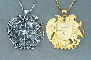 Detail of vintage eagle and lion crest pendants in gold and silver finish with chains
