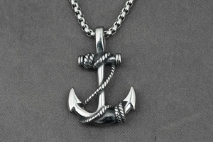Gros plan macro d'un pendentif ancre en argent avec texture de corde et chaîne solide