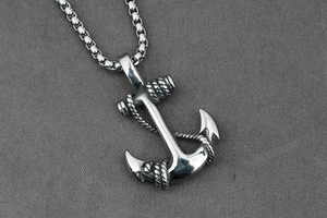 Vue détaillée d'un pendentif ancre argenté avec texture corde sur une chaîne box