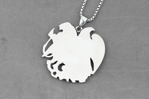 Macro shot of silver eagle shield pendant with square pearl chain and polished metallic back