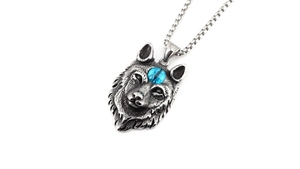 Gros plan détaillé du pendentif tête de loup rétro avec pierre bleue et chaîne