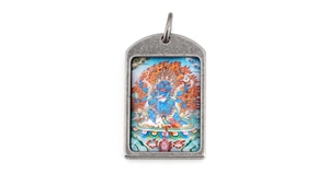 Macro detail of retro stainless steel Buddhist Thangka pendant with Mahakala deity graphic