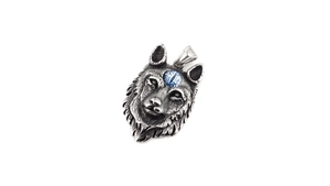 Vue détaillée du pendentif tête de loup vintage avec œil bleu sur acier poli