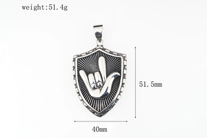 Detalle del colgante de escudo con gesto rock mostrando dimensiones y peso de 51,4g