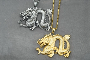 Detail von Gold- und Silber-Drachenanhängern mit feinen Schuppen und Metallketten