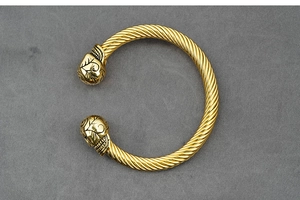 Detailed close-up of gold-plated cable wire cuff bracelet with engraved leaf pattern ends