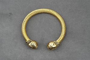 Close-up of gold twisted cable cuff bracelet with vintage floral relief patterns