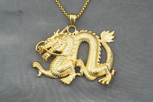 Detailaufnahme des goldenen Drachenanhängers mit fein ziselierten Schuppen und 3D-Gravur