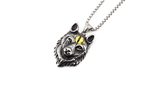 Détail du pendentif tête de loup vintage avec œil jaune sur une chaîne de type boîte