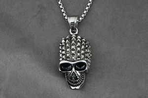 Macro shot of punk style silver skull pendant with mohawk spikes and aged finish