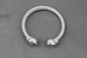 Detailed macro view of punk style silver twisted cable bracelet with engraved ball ends