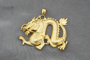 Makro-Detail des goldenen chinesischen Drachenanhängers mit fein gravierten Schuppen
