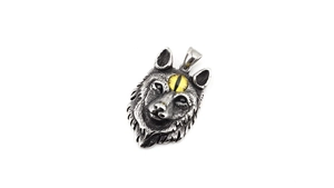 Détail du pendentif tête de loup argenté vintage avec œil jaune et texture de fourrure