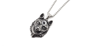Détail du pendentif tête de loup en acier titane vintage avec un œil et finition argent