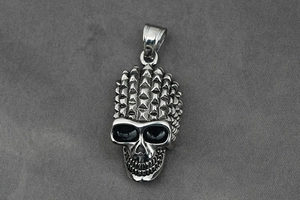 Detail of silver skull pendant with punk rivet spikes and dark eye sockets for necklace
