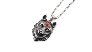 Détail macro du pendentif tête de loup rétro avec œil rouge sur une chaîne en acier