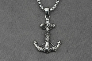Macro shot of silver anchor pendant with rope detail and stainless steel box chain