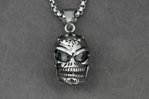 Macro shot of punk style skull pendant in antique silver finish with detailed metal texture