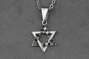 Vue macro d'un pendentif hexagramme vintage en acier titane avec cristaux noirs