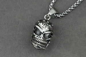Detailed close-up of a punk-style skull pendant in vintage silver-finished stainless steel