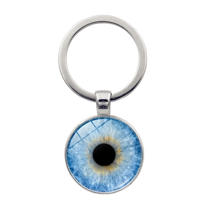 Detail macro of silver metal key ring with blue eye glass dome pendant and pupil texture