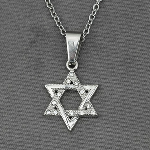 Collier avec pendentif hexagramme argenté et zircons cubiques sur fond gris texturé