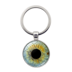 Detail of silver alloy keychain with realistic blue and yellow iris glass dome pendant