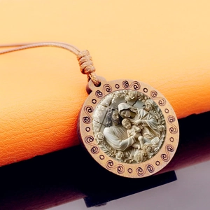 Vue macro du pendentif rond en bois de la Sainte Famille avec motifs en spirale