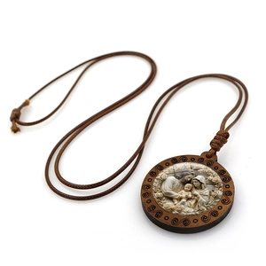 Détail du pendentif rond en bois avec relief de la Sainte Famille et cordon marron