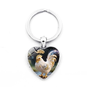 Close-up of heart-shaped keychain featuring a colorful white rooster and auspicious clouds